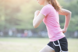 Woman runs outside in pink t-shirt and black workout shorts